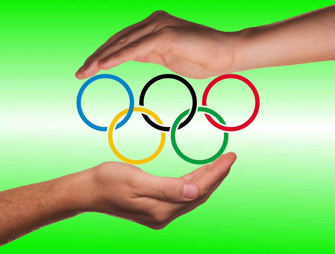 mains protégeant les anneaux olympiques